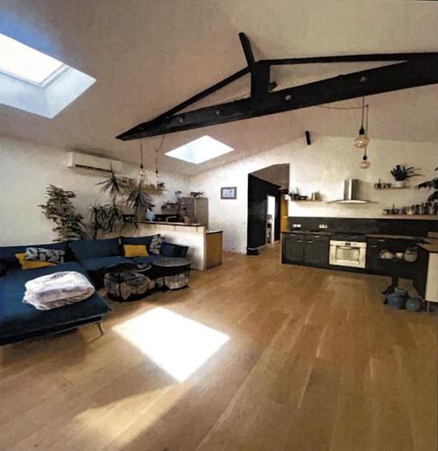 uma sala de estar com um sofá azul e uma cozinha em Le cabanon planqué em Bordeaux