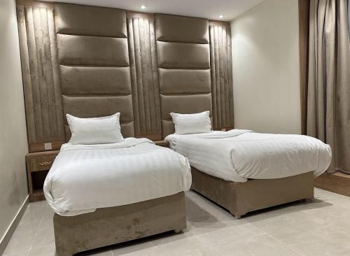 twee bedden naast elkaar in een slaapkamer bij اطلالة الحوراء in Umm Lajj