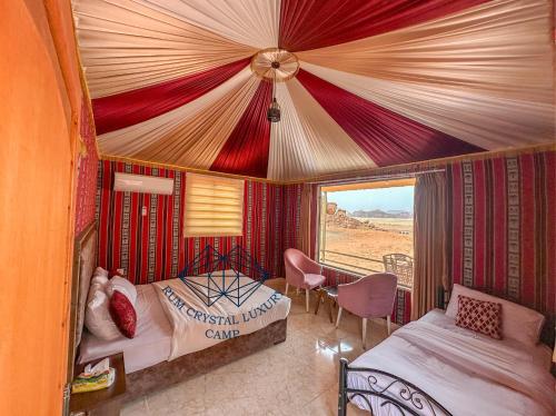 a bedroom with two beds and a view of the desert at Rum Crystal Luxury Camp in Wadi Rum