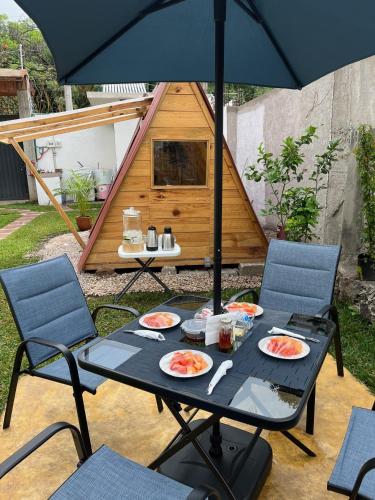a table with plates of food and an umbrella at Hostal Gautamas Guest rooms, hostal para viajeros,backpackers hostel in Tepoztlán