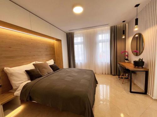 a bedroom with a large bed and a desk at LEO Apartment FREE PARKING - President Palace in Bratislava