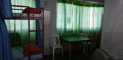 een kamer met 2 stapelbedden en een tafel en stoelen bij Quickshape/Quickshield Homestay in Naga