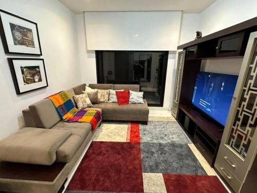 uma sala de estar com um sofá e uma televisão de ecrã plano em casa en samborondon em Guayaquil