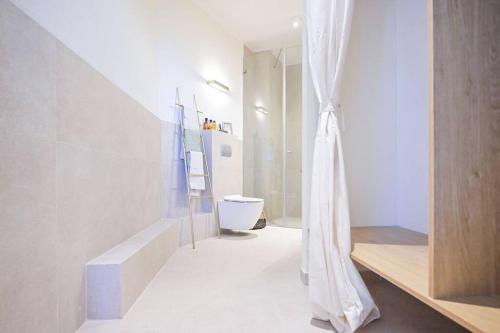 La salle de bains est pourvue d'un rideau de douche et de toilettes. dans l'établissement Mykonos Vibes - 3 BR, à Tel Aviv