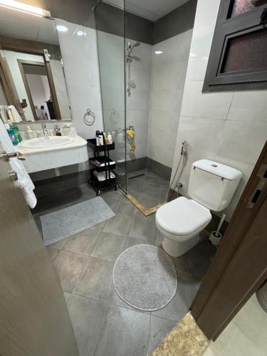 a bathroom with a toilet and a sink and a shower at sharja 1103 in Sharjah