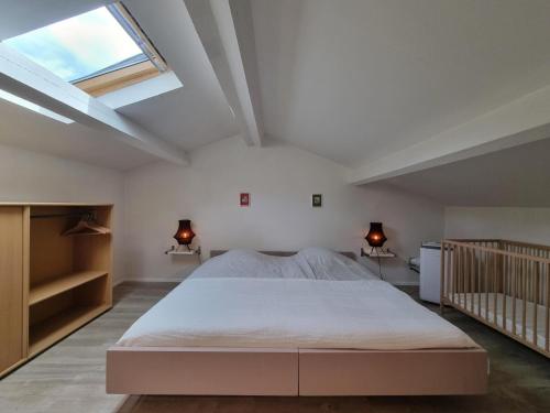 ein Schlafzimmer mit einem großen Bett und einem Dachfenster in der Unterkunft Le Castelas in Boisset