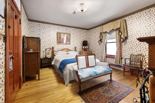 1 dormitorio con 1 cama y 1 silla en Le Griffon, en Shediac