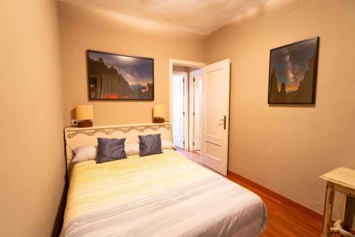 um quarto com uma cama com duas almofadas azuis em El Cervunal em Arenas de San Pedro