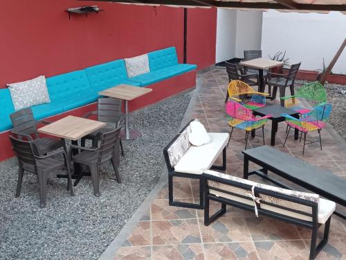 un restaurant avec des tables, des chaises et un banc bleu dans l'établissement Hospedaje Casa Cultural Saberes, à Neiva