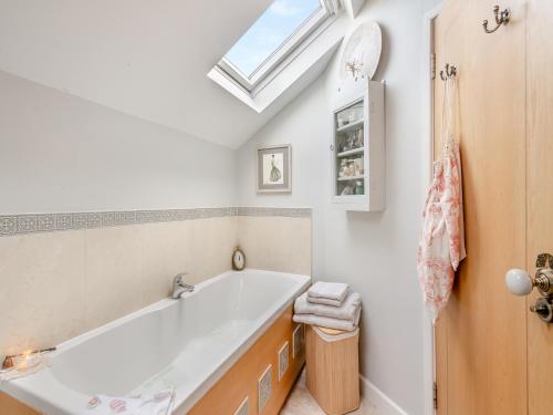 a bathroom with a large tub and a skylight at Ocean View in Lowestoft