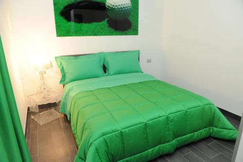 トリノにあるResidenza Menabreaの緑の掛け布団付きのベッドルームの緑のベッド