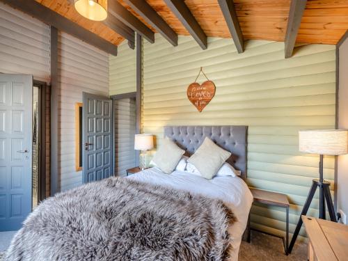 a bedroom with a bed and a sign on the wall at 5 The Glades - Uk46753 in Tattershall