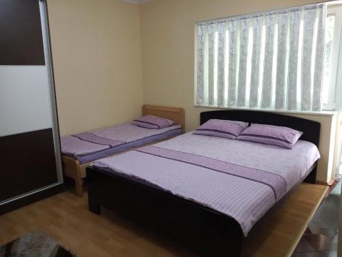 due letti in una camera da letto con cuscini viola di Apartment Gino a Ohrid