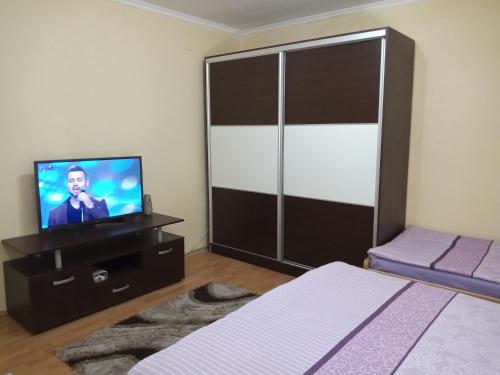un soggiorno con una tv, un letto e un televisore di Apartment Gino a Ohrid