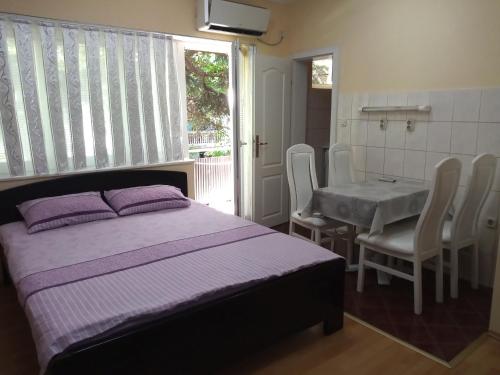 una camera da letto con un letto, un tavolo e delle sedie di Apartment Gino a Ohrid