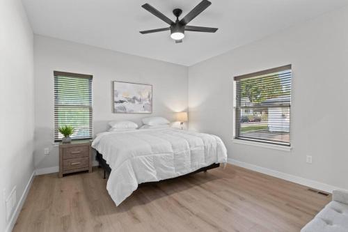 a white bedroom with a bed and a ceiling fan at Dells Domain in Wisconsin Dells