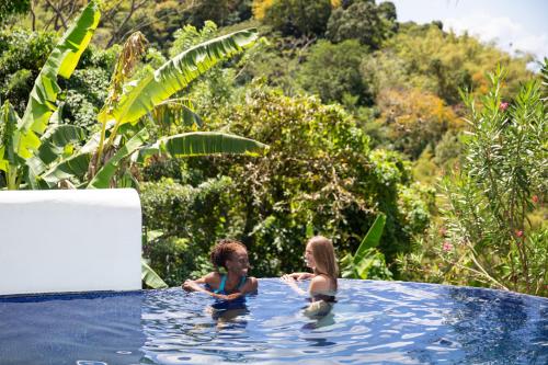 Maran的住宿－Mount Edgecombe Boutique Hotel，两个孩子在游泳池游泳