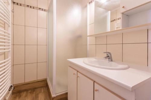a white bathroom with a sink and a mirror at Résidence Vercors - 3 Pièces pour 7 Personnes 474 in La Plagne Tarentaise