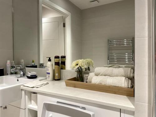 a white bathroom with a sink and a mirror at London Southgate 2bed Apartment in London