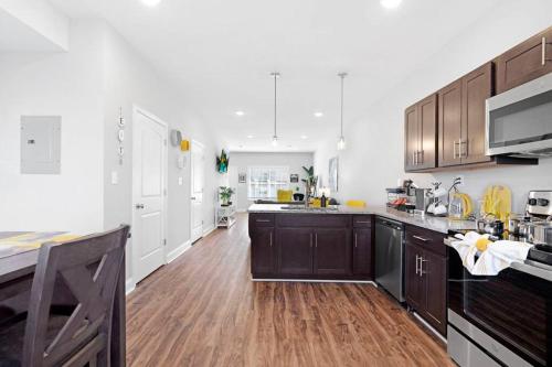 a large kitchen with wooden floors and white walls at Make Lemonade in luxury w king bed and free parking plus 40 minutes to Nashville in Clarksville