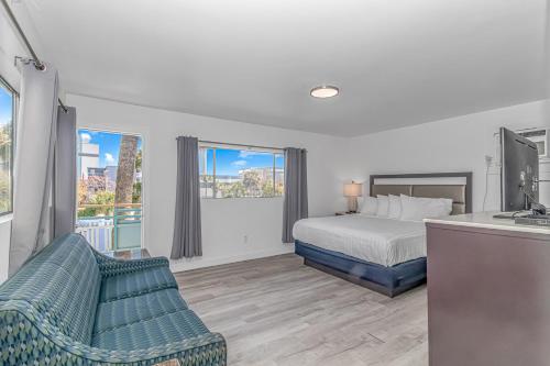 een slaapkamer met een bed, een bank en ramen bij Sun Fun in Myrtle Beach