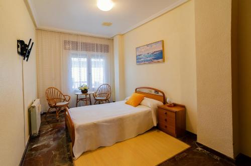 1 dormitorio con 1 cama y 1 mesa con sillas en Villa Taala con terraza, en Los Nietos