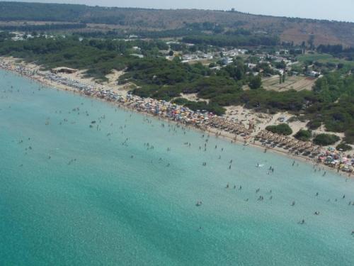 eine Luftansicht auf einen Strand mit Menschen im Wasser in der Unterkunft Hotel Spiaggia Conchiglie in Gallipoli