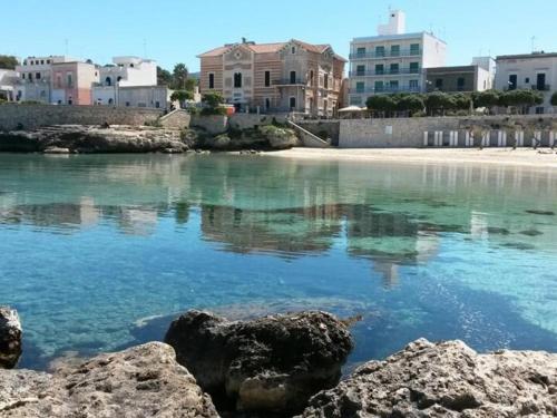 einem Wasserkörper mit Gebäuden im Hintergrund in der Unterkunft Hotel Spiaggia Conchiglie in Gallipoli