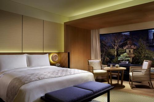 a bedroom with a bed and a table and chairs at The Ritz-Carlton Kyoto in Kyoto