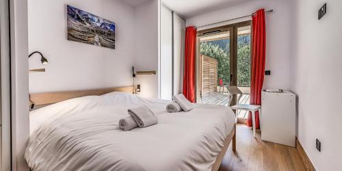 - une chambre avec un grand lit blanc et des rideaux rouges dans l'établissement Résidence Les Terrasses De La Vanoise - CASA COLORADO - PREMIUM 4 - Appartement de 4 pièces 8 personnes en rez de chaussée - 72 m2 MAE-1504, à Champagny-en-Vanoise