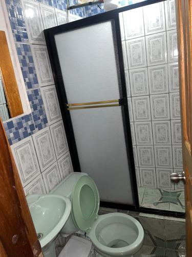 a bathroom with a toilet and a sink at Hostal Don Viche in Mindo