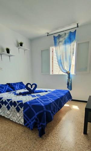 a blue bed in a white room with a window at Sunny Room in Habitat in Maspalomas