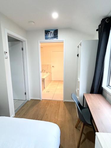 a bedroom with a bed and a desk and a bathroom at 26 Gladstone Rd Highgate Hill in Brisbane