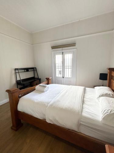 a bedroom with a large white bed and a window at 26 Gladstone Rd Highgate Hill in Brisbane