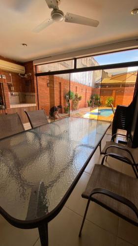 einen großen Glastisch im Wohnzimmer mit Stühlen in der Unterkunft Casa Hotel Confortable in Encarnación