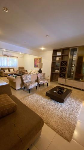 sala de estar con sofás y alfombra en Casa Hotel Confortable en Encarnación
