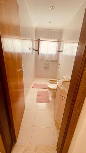 a bathroom with a toilet and a sink at Casa Hotel Confortable in Encarnación