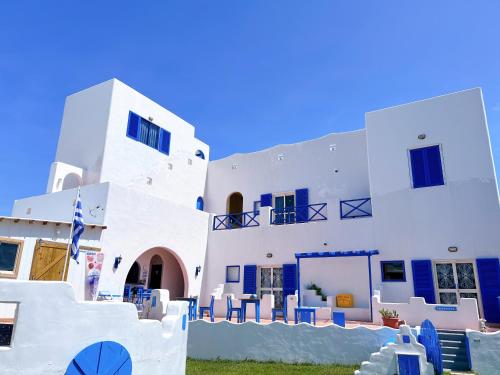 un grande edificio bianco con sedie blu davanti di Greek Frontier Villa a Magong