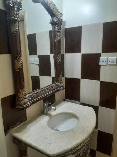 y baño con lavabo y espejo. en فله, en Ad Dawādimī