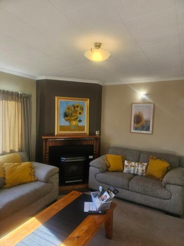 a living room with two couches and a coffee table at Holden's Hideaway MBT in Rotorua