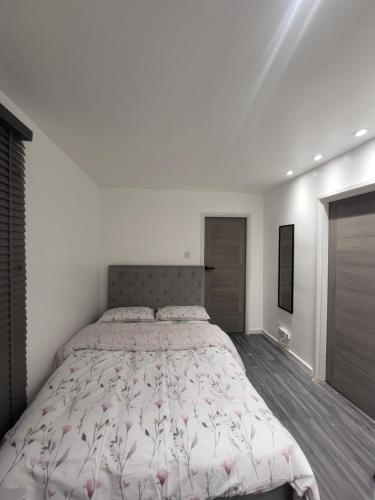 een slaapkamer met een groot bed met roze bloemen erop bij Fuzzys place in Londen