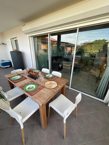 a wooden table with white chairs and a dining room at Appartement Saint Martin Friars Bay Sunset Paradise in Friar's Bay