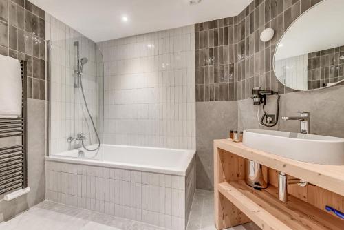 une salle de bain avec une baignoire, un lavabo et un miroir dans l'établissement Résidence Le Grand Bouquetin - 3 Pièces pour 6 Personnes MAE-0004, à Champagny-en-Vanoise