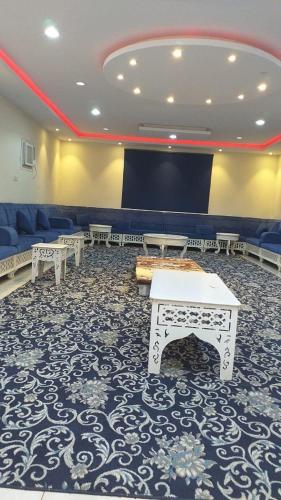 a conference room with tables and a projection screen at جوهرة الرعيلة in Al Laqīţah