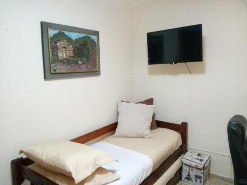 a room with a bed and a flat screen tv at Condominio Binacional in Santana do Livramento