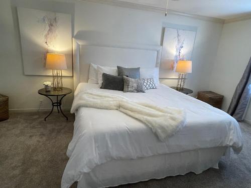 een slaapkamer met een wit bed en 2 lampen bij The Terrace Room @ Galleria in Houston