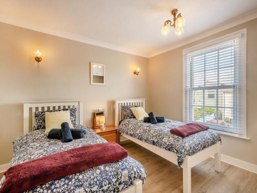 a bedroom with two beds and a window at Curlew Cottage in Caister-on-Sea