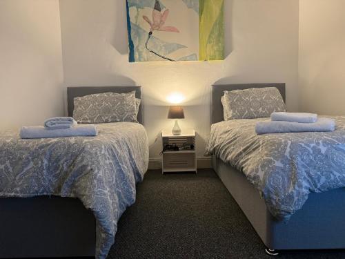 a bedroom with two beds with blue comforters at 140 MAIN ST GROUND LEFT in Largs