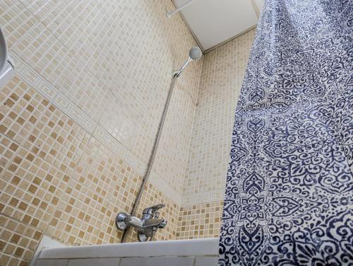 um chuveiro com uma cortina de chuveiro azul e branco em Comfort Bed Inn no Dubai