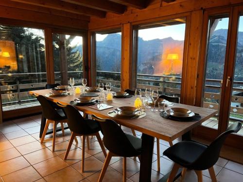 a dining room with a table and chairs and windows at Résidence Le Cristal - Chalets pour 8 Personnes 154 in Crest-Voland